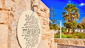 Un muro de piedra con un letrero circular que dice "margarita".