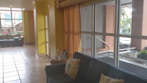 Een modern interieur met een groot raam, een bank en een bijzettafeltje met tijdschriften.