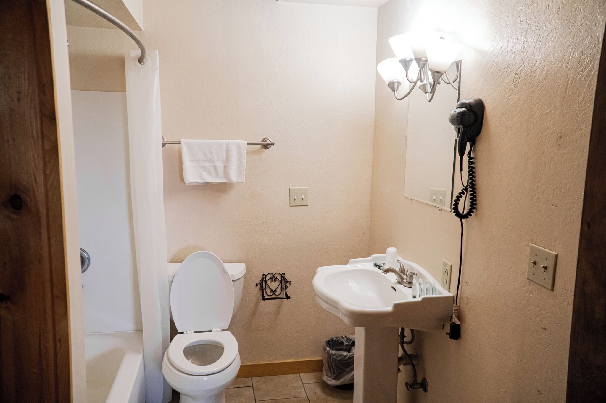 A bathroom with a toilet, sink, and shower.