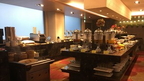 A buffet area with multiple food stations, a coffee machine, and a variety of dishes displayed on a marble counter. - Park City Central (Taichung)