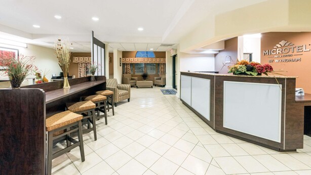 A reception area with a counter, seating, and a view of the lobby. - Microtel Inn and Suites Eagle Pass (Eagle Pass)