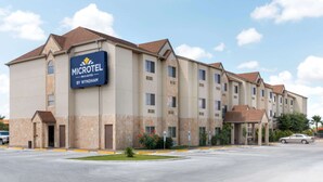 A Microtel Inn & Suites building with a stone facade, multiple windows, and a parking lot. - Microtel Inn and Suites Eagle Pass (Eagle Pass)
