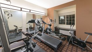A gym with a treadmill, elliptical, and weight bench. - Microtel Inn and Suites Eagle Pass (Eagle Pass)