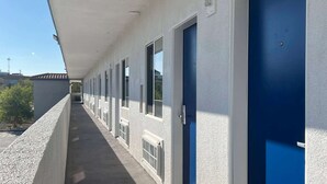 A long corridor with blue doors and windows, leading to individual rooms.