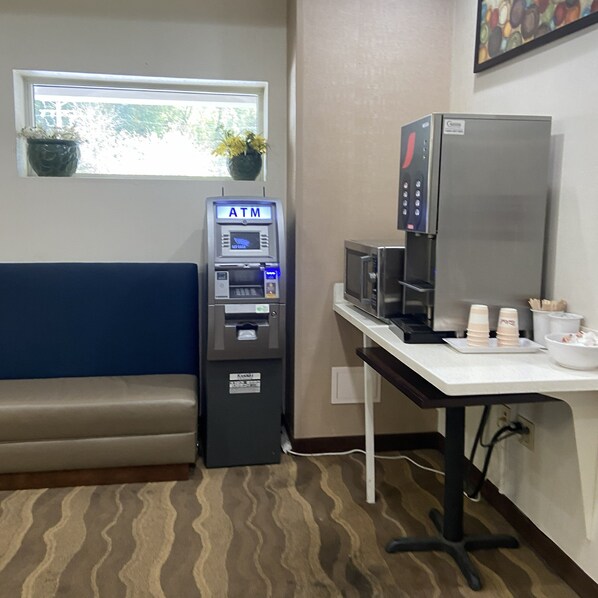 A small room with a blue bench, an ATM, a microwave, and a coffee machine. - Red Roof Inn Pittsburgh - McKnight Rd (Pittsburgh)