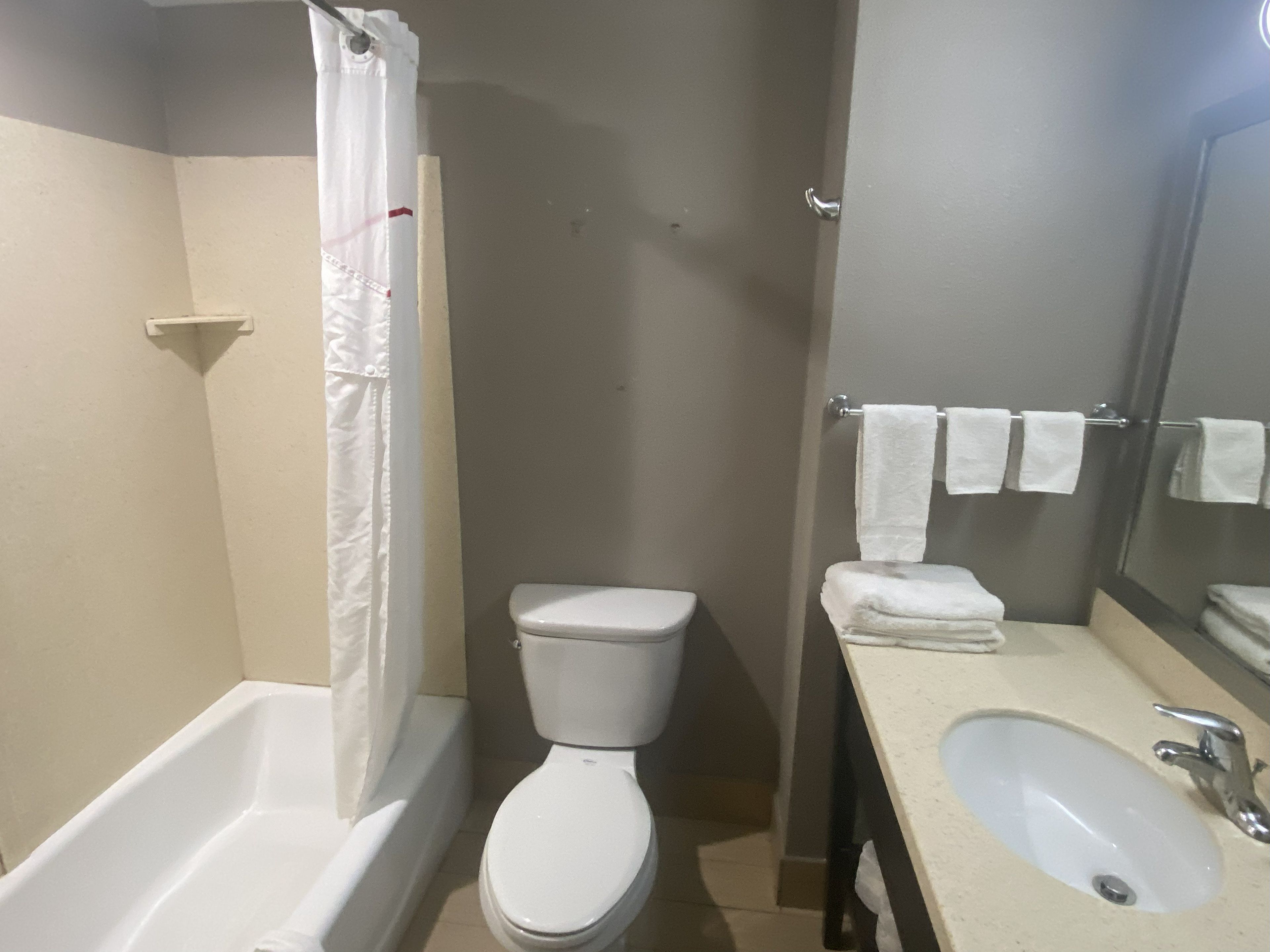 Un baño con bañera, inodoro y lavamanos.