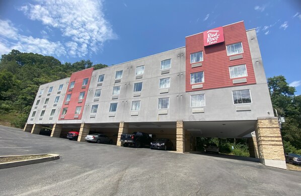 A Red Roof Inn building with a red and grey facade, multiple floors, and a parking garage. - Red Roof Inn Pittsburgh - McKnight Rd (Pittsburgh)