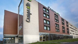 A multi-story hotel with a prominent 'Camping' sign on the facade, large windows, and a 'Restaurant' sign indicating on-site dining. - Campanile Wroclaw Centrum (Wroclaw)