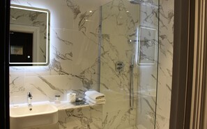 A modern bathroom with a marble shower, a sink, and a mirror. - Warren House (Kingston Upon Thames)