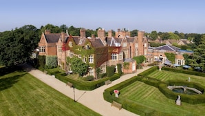 A large, historic building with multiple wings and a well-maintained garden with hedges and a fountain. - Warren House (Kingston Upon Thames)