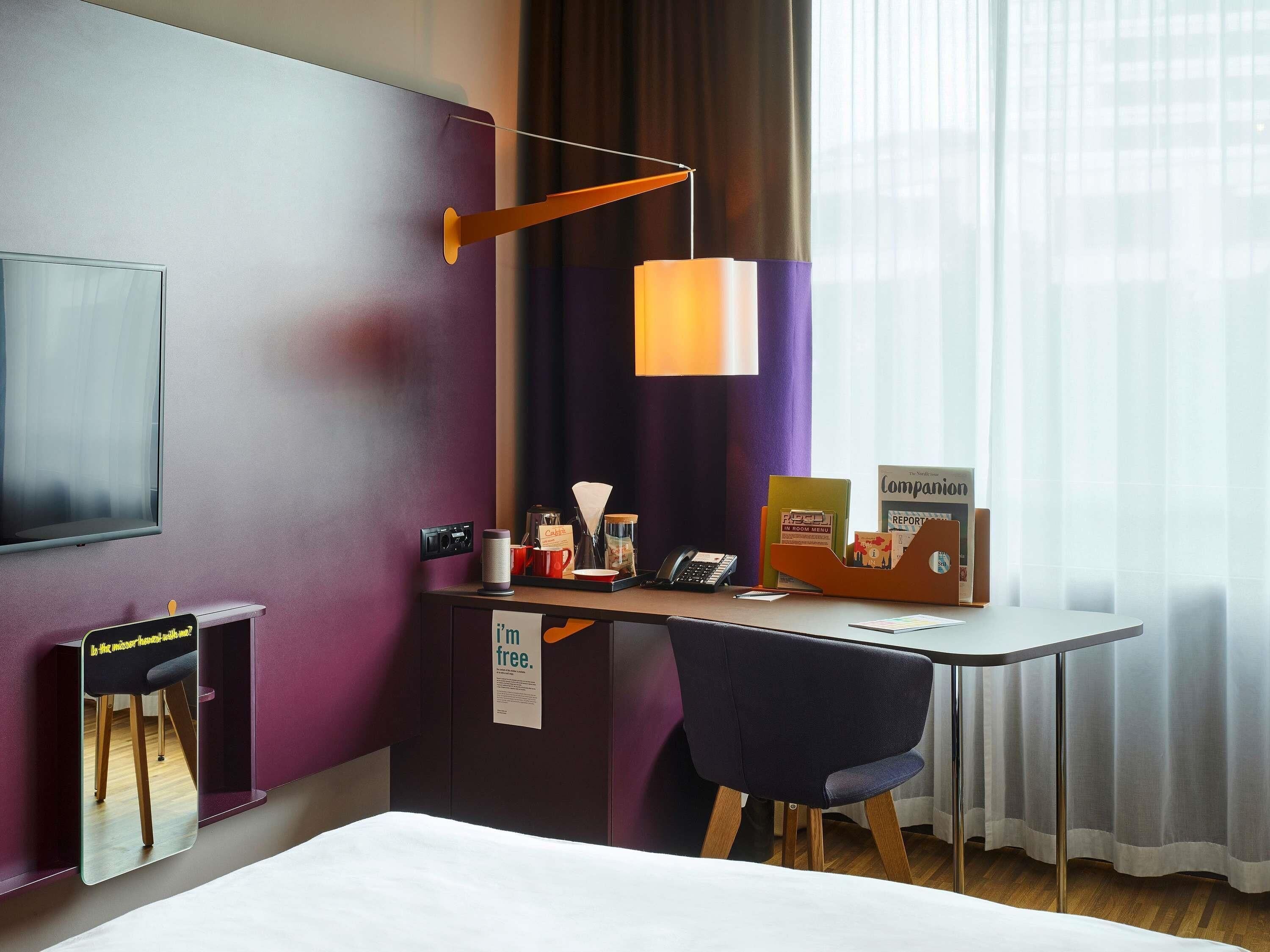 Een hotelkamer met een bureau, stoel en bed.
