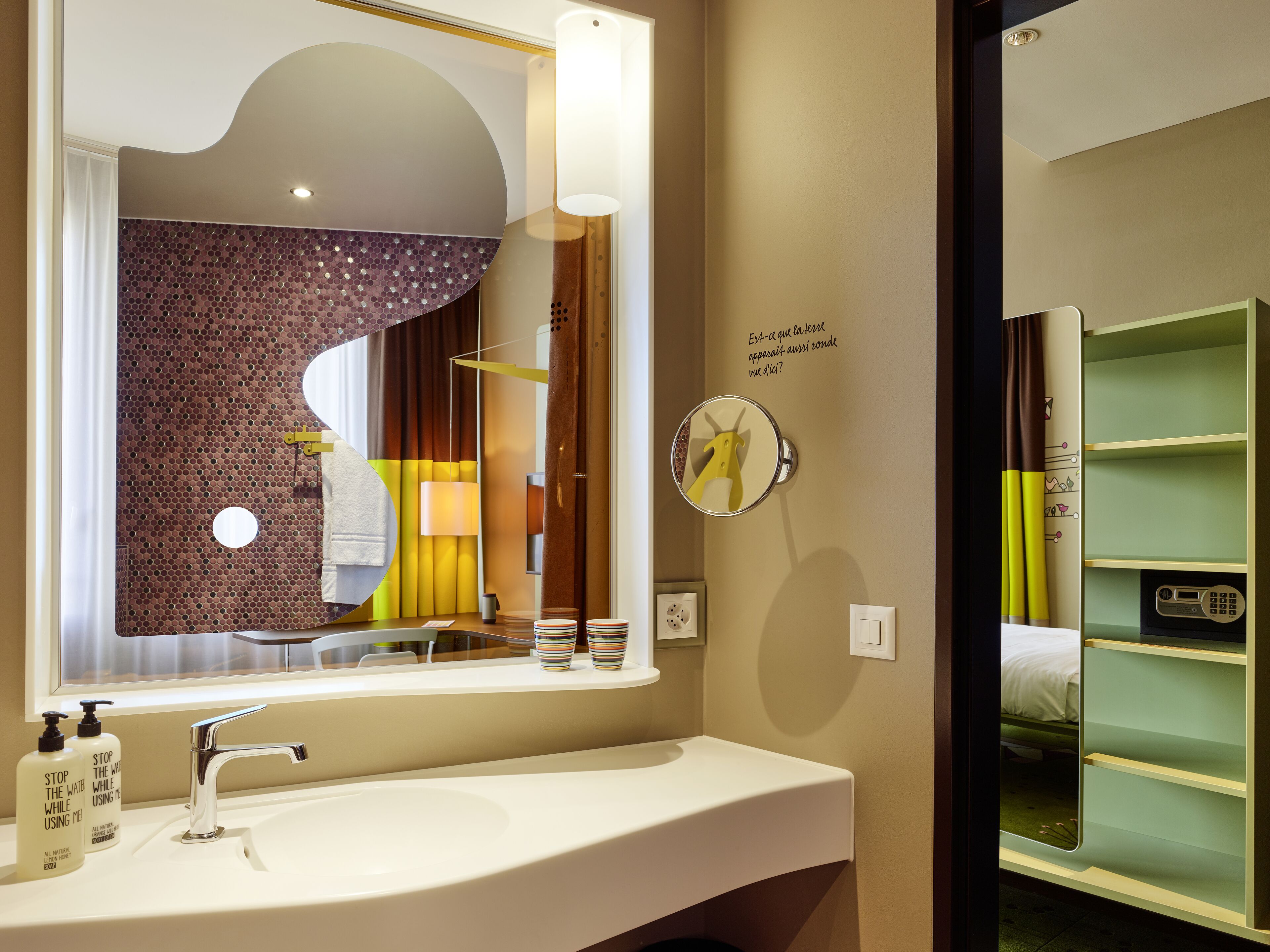 A bathroom with a large mirror, a sink, and a vanity with shelves.