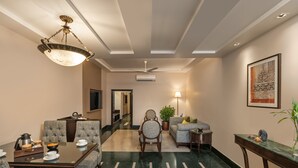 A hotel lobby with a dining area, seating arrangements, a chandelier, a ceiling fan, and a large framed artwork on the wall. - Ganga Lahari, Haridwar (Haridwar)