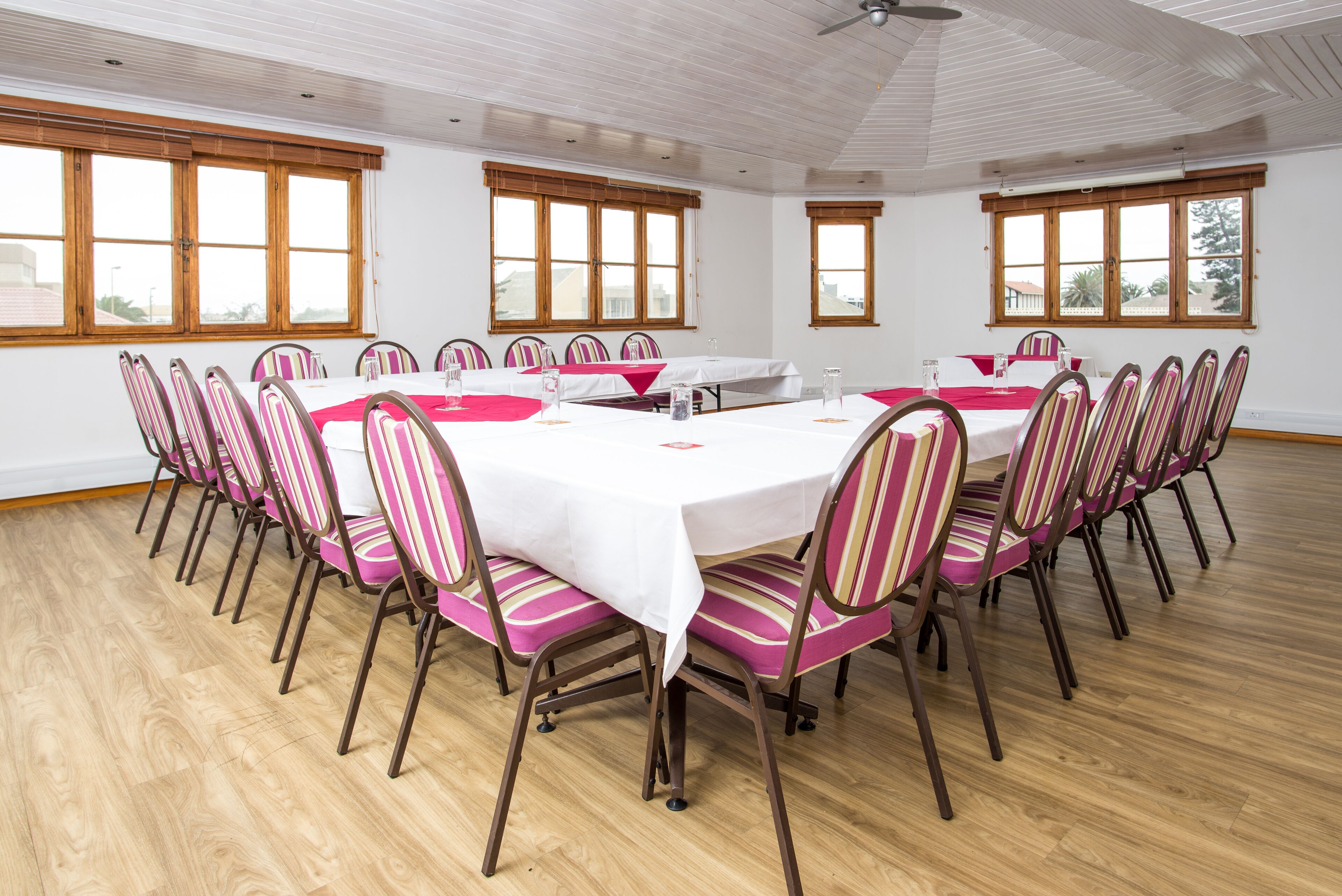 A conference room with a large table, chairs, and windows.