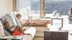 A modern living room with a sofa, a coffee table, and a view of the outdoors.