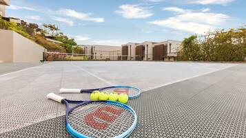 Un court de tennis avec deux raquettes de tennis et trois balles de tennis.