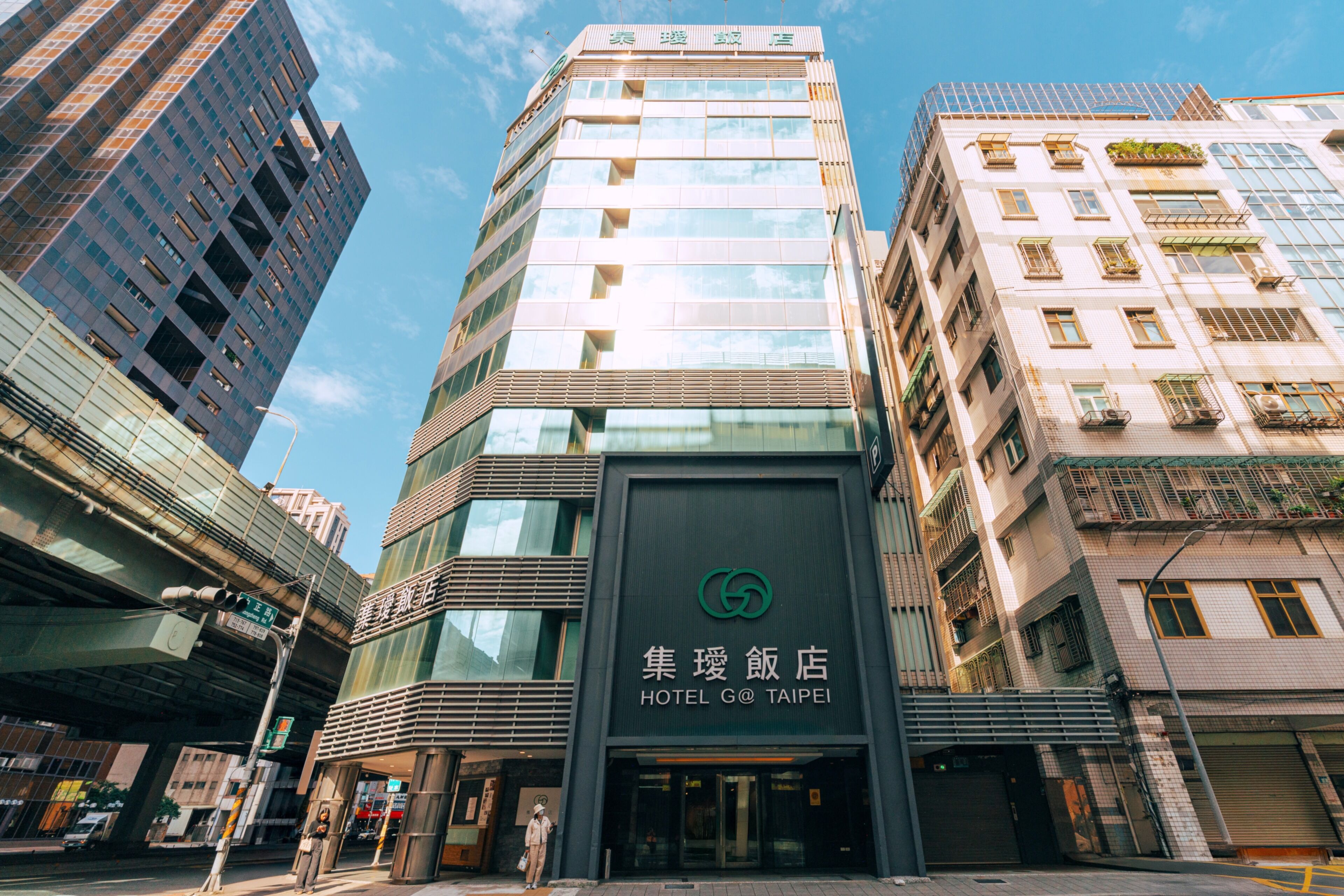 A modern hotel building with a prominent logo and signage.