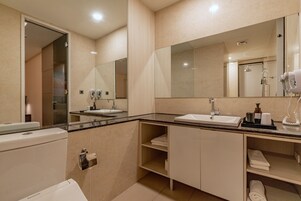 Un baño moderno con un espejo grande, un lavabo y un inodoro.