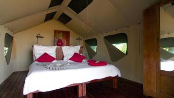 A tent-style bedroom with a bed, pillows, and a heart-shaped decoration.