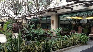 A landscaped area with various plants and a seating area with tables and chairs. - Royal Panerai Hotel (Chiang Mai)