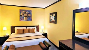 A hotel room with a bed, bedside tables, lamps, and artwork on the walls. - Royal Panerai Hotel (Chiang Mai)