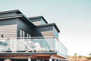 A modern house with a balcony and a clear view of the surrounding landscape.
