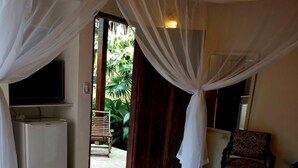 A bedroom with a bed, a TV, and a desk. - Pousada Magia Verde (Paraty)