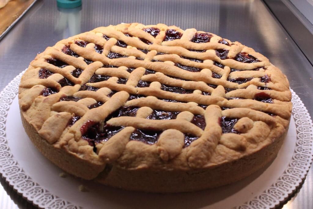 A pie with a lattice crust on a white plate.