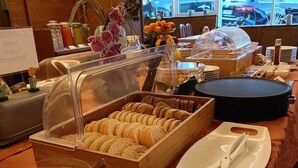 A buffet setup with various food items, including pastries and eggs, and dining utensils. - Albergo Ristorante Cacciatori  (Auronzo di Cadore)