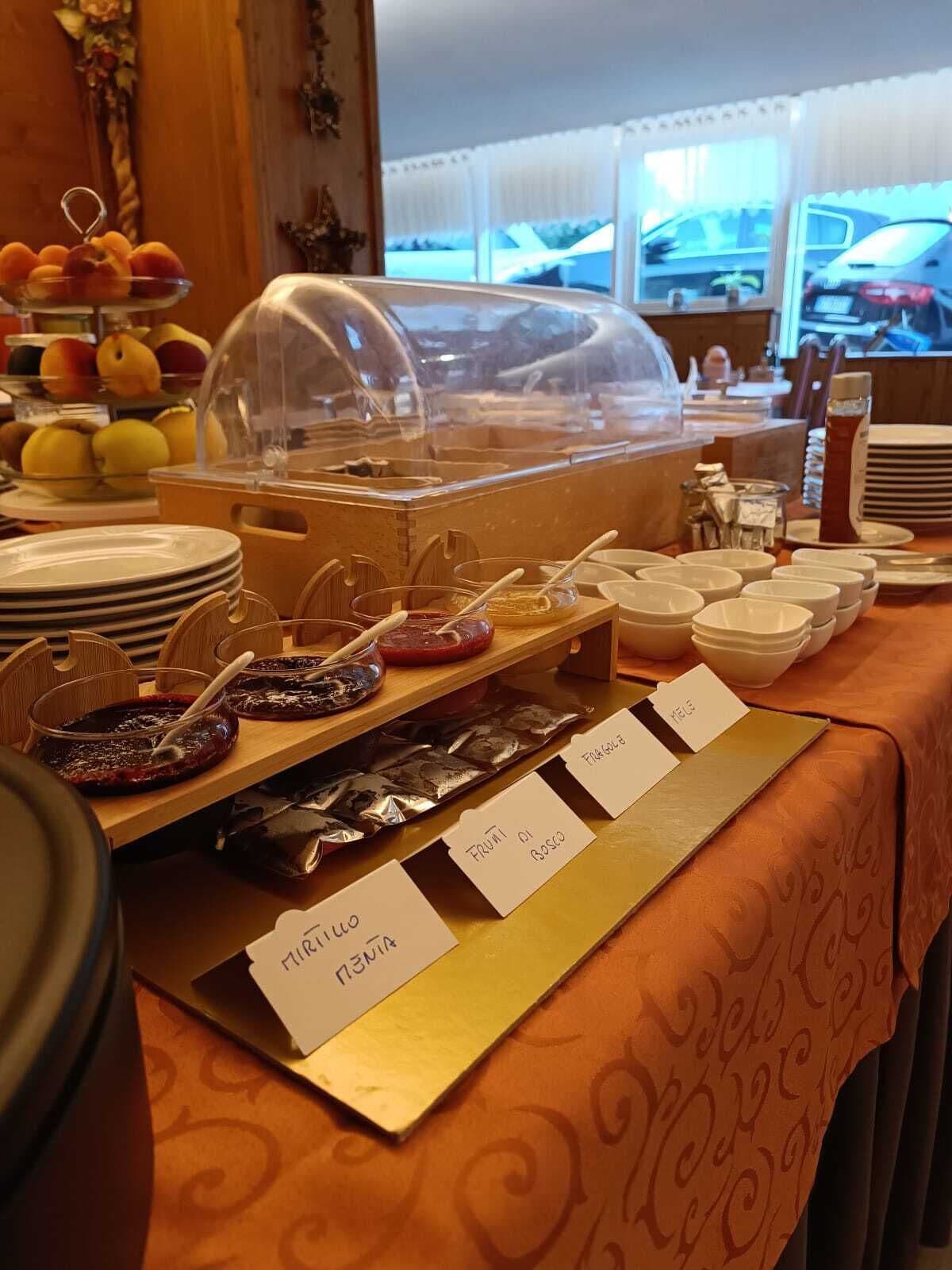 A buffet setup with various food items and serving utensils.