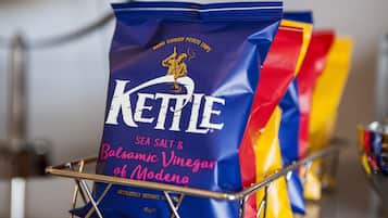 A bag of Kettle sea salt and balsamic vinegar of Modena in a metal basket.