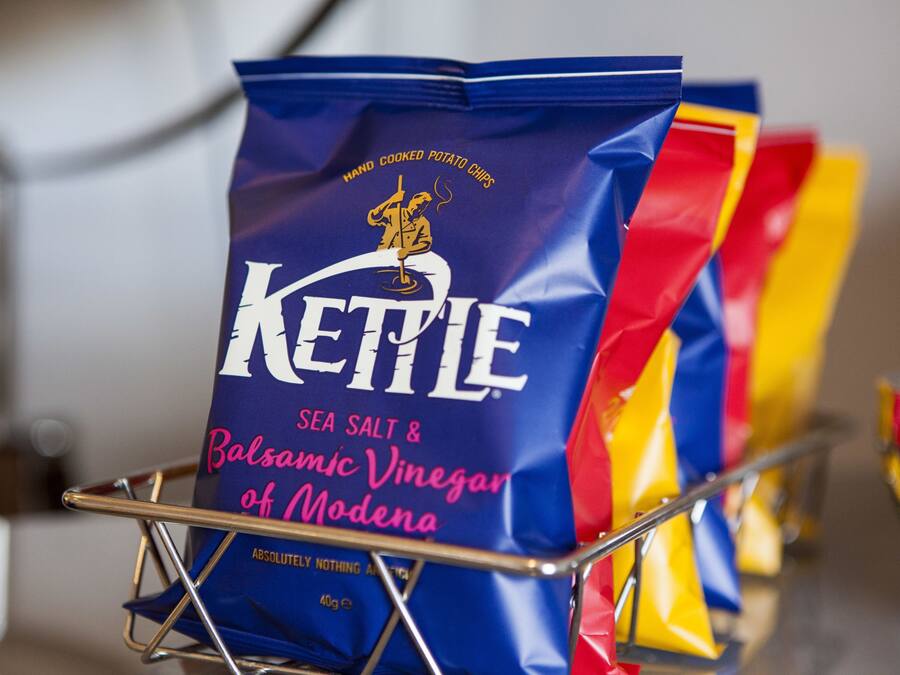 A bag of Kettle sea salt and balsamic vinegar of Modena in a metal basket.