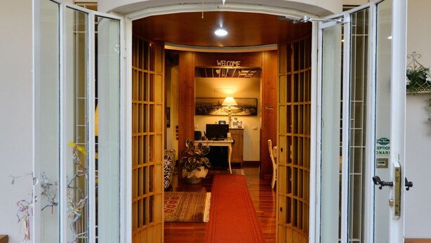 A hotel entrance with a red carpet leading to a reception desk. - Villa Bianca (Sona)