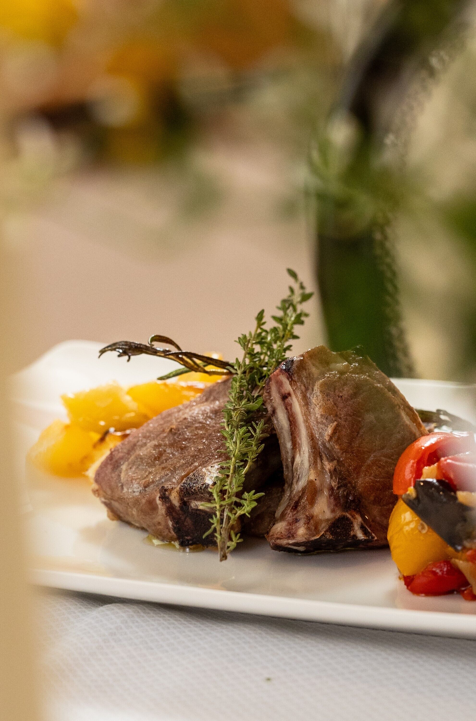 Une assiette contenant un plat de viande cuite, agrémenté d’herbes et de légumes.