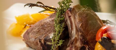 Un plato con un guiso de carne, adornado con hierbas y vegetales.