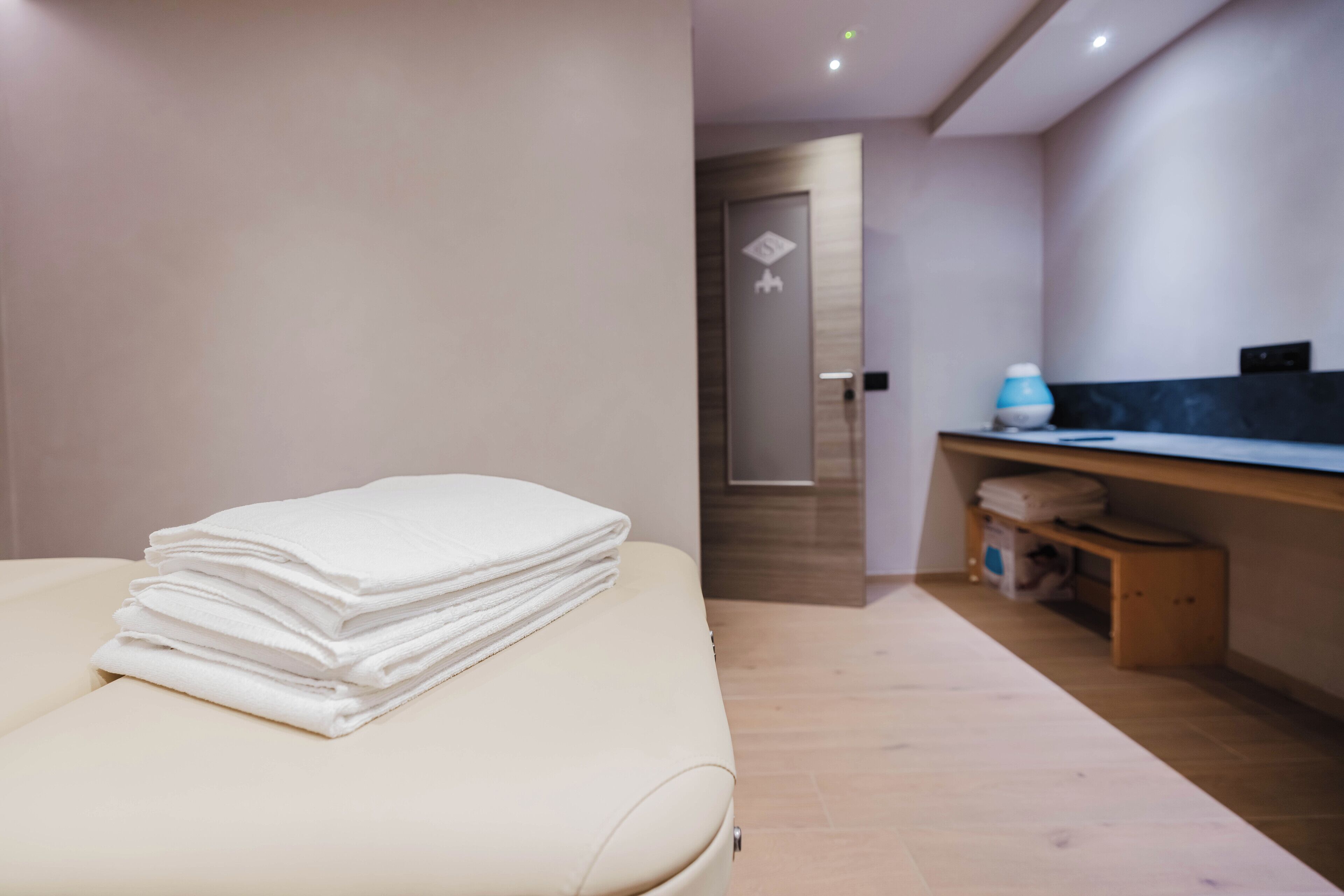 A hotel room with a bed, a small desk, and a bathroom door.