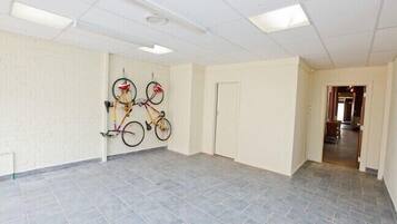 A spacious hallway with grey tiled flooring, white walls, and a ceiling with recessed lighting.