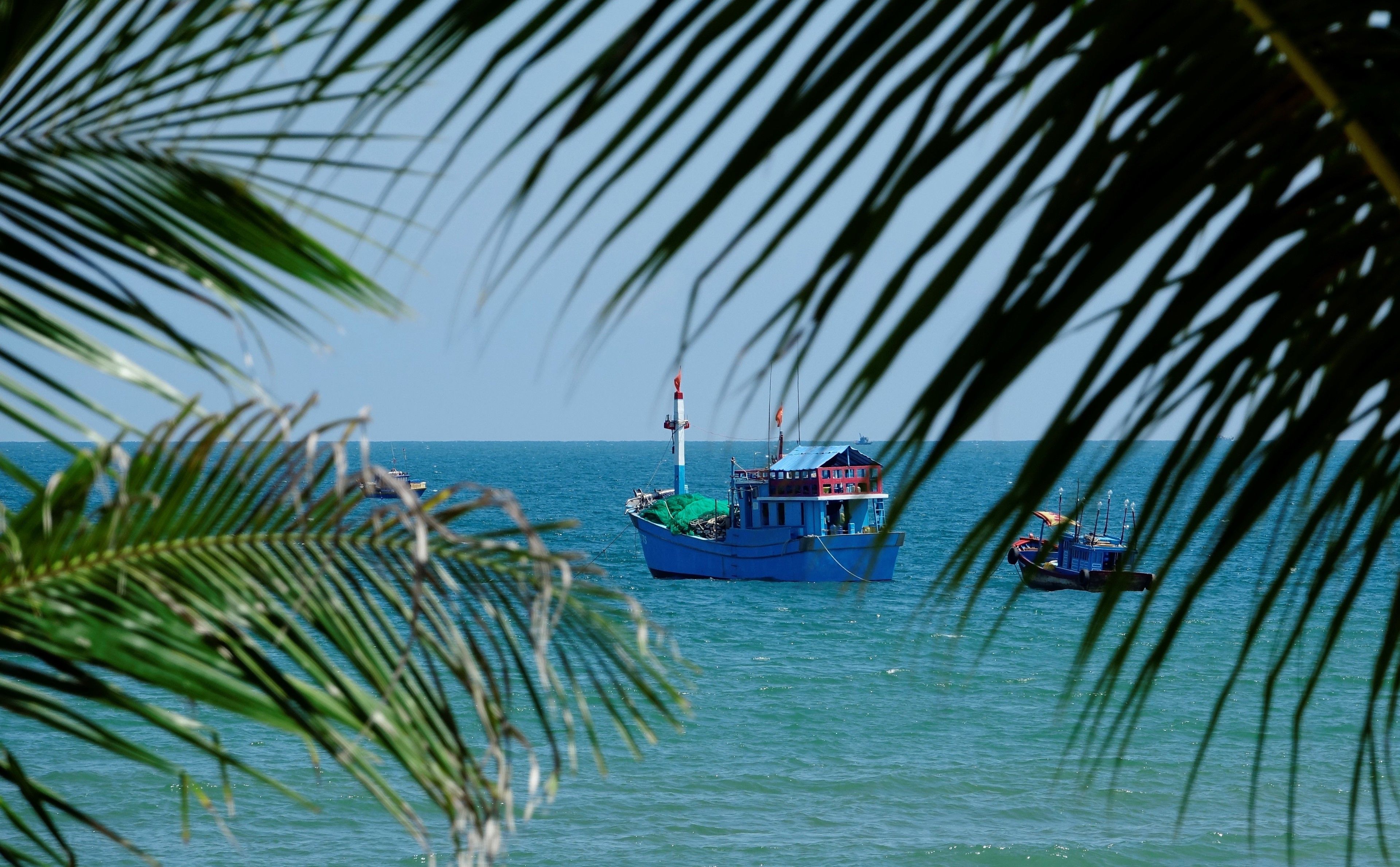A boat docked at a pier with a clear view of the ocean.