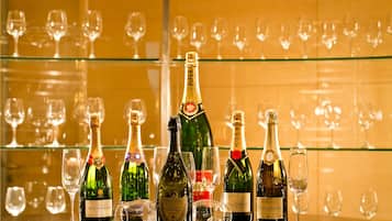 Uma área de bar com diversas garrafas de champanhe e copos de vinho.