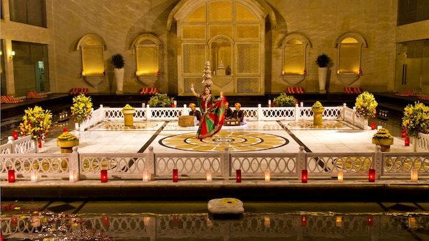 Un área ceremonial con una plataforma central, una fuente y un estanque reflectante.