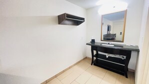 Une salle de bain avec un meuble-lavabo noir, un miroir et un porte-serviettes.