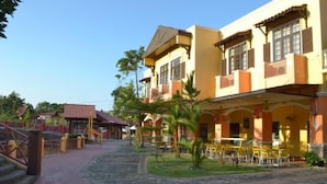 A building with a covered outdoor seating area and a paved walkway. - GeoPark Hotel (Langkawi)