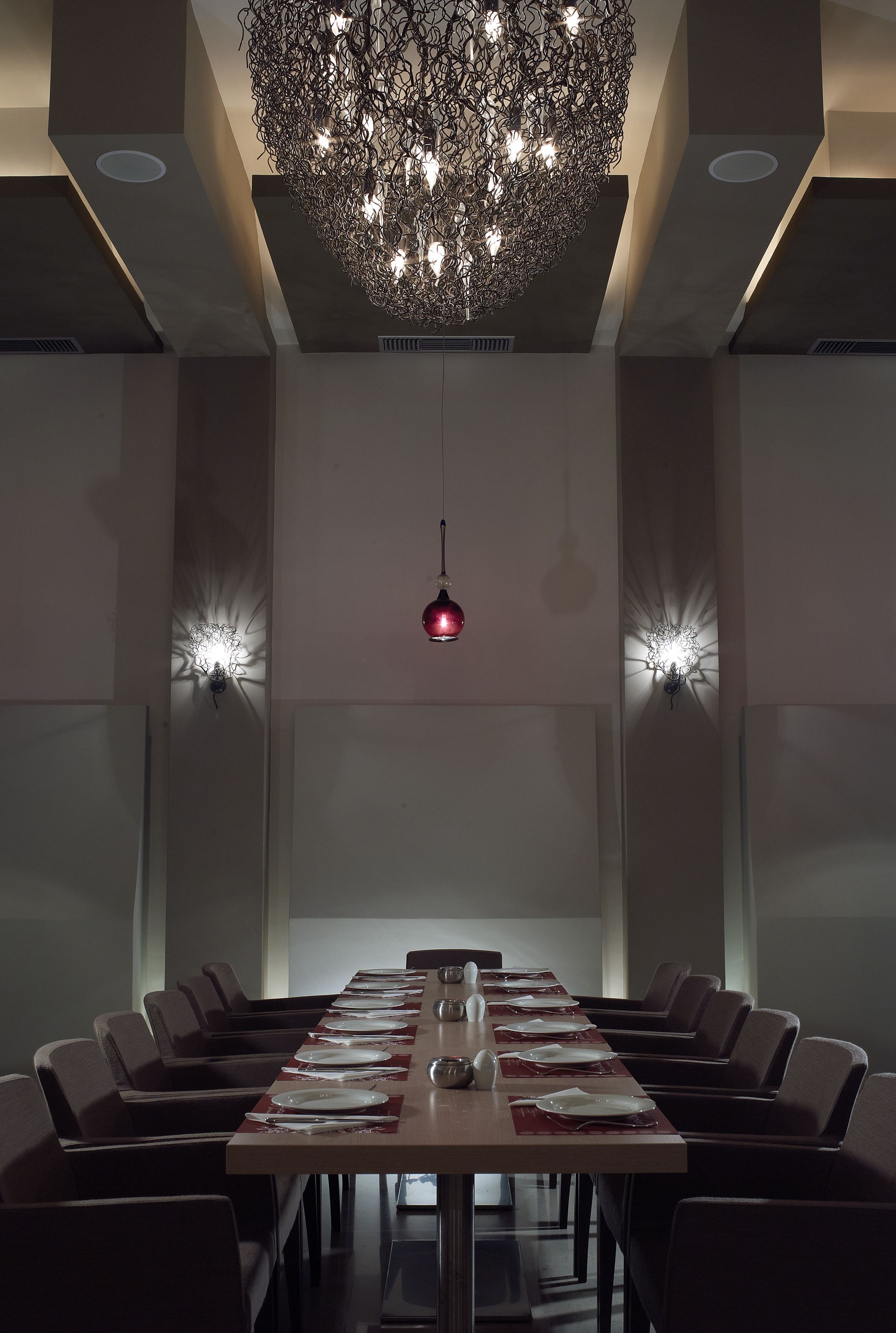 A conference room with a long table, chairs, and a chandelier.