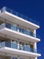 Un edificio de varios pisos con balcones y ventanas amplias.