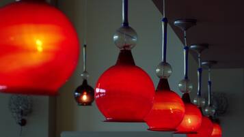 A row of hanging red pendant lights with spherical glass shades and metallic accents.