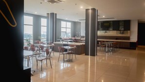 A modern restaurant with a central island, high ceilings, and large windows. - ROOMS INC d’botanica Bandung (Bandung)