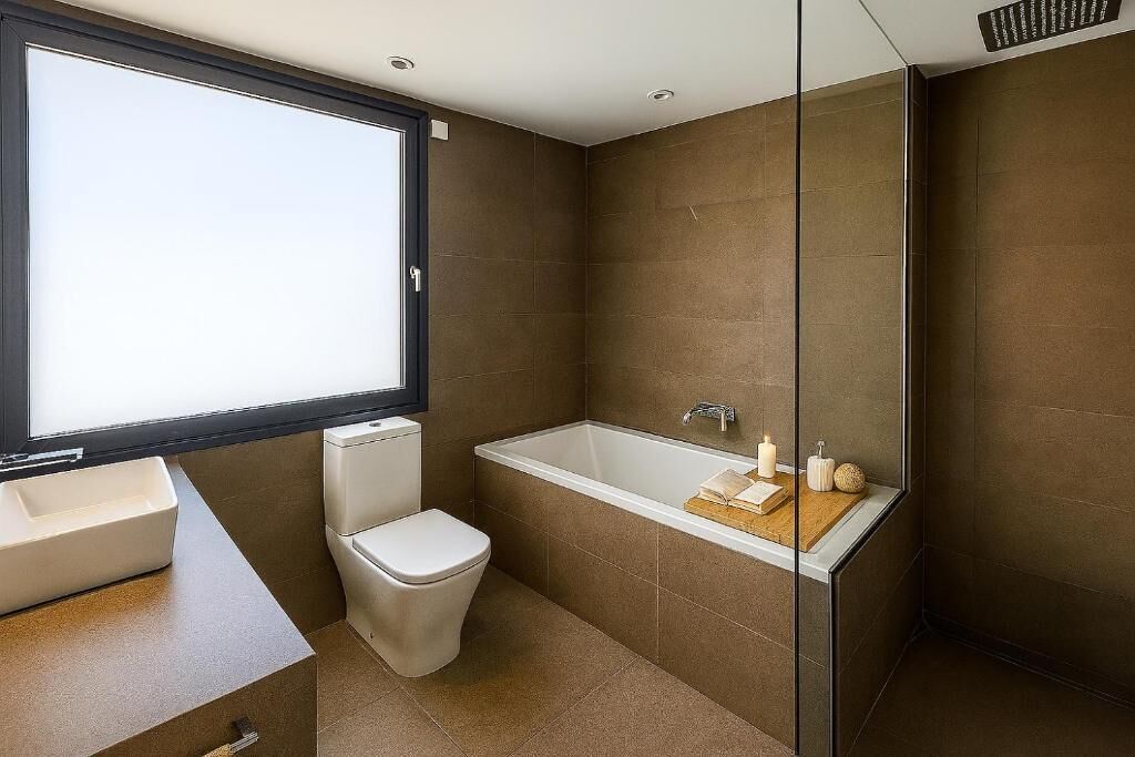 Un bagno moderno con vasca, servizi igienici e lavandino.