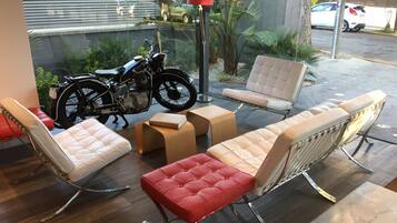 Un área de estar moderna al aire libre con sillas acolchadas y una motocicleta.