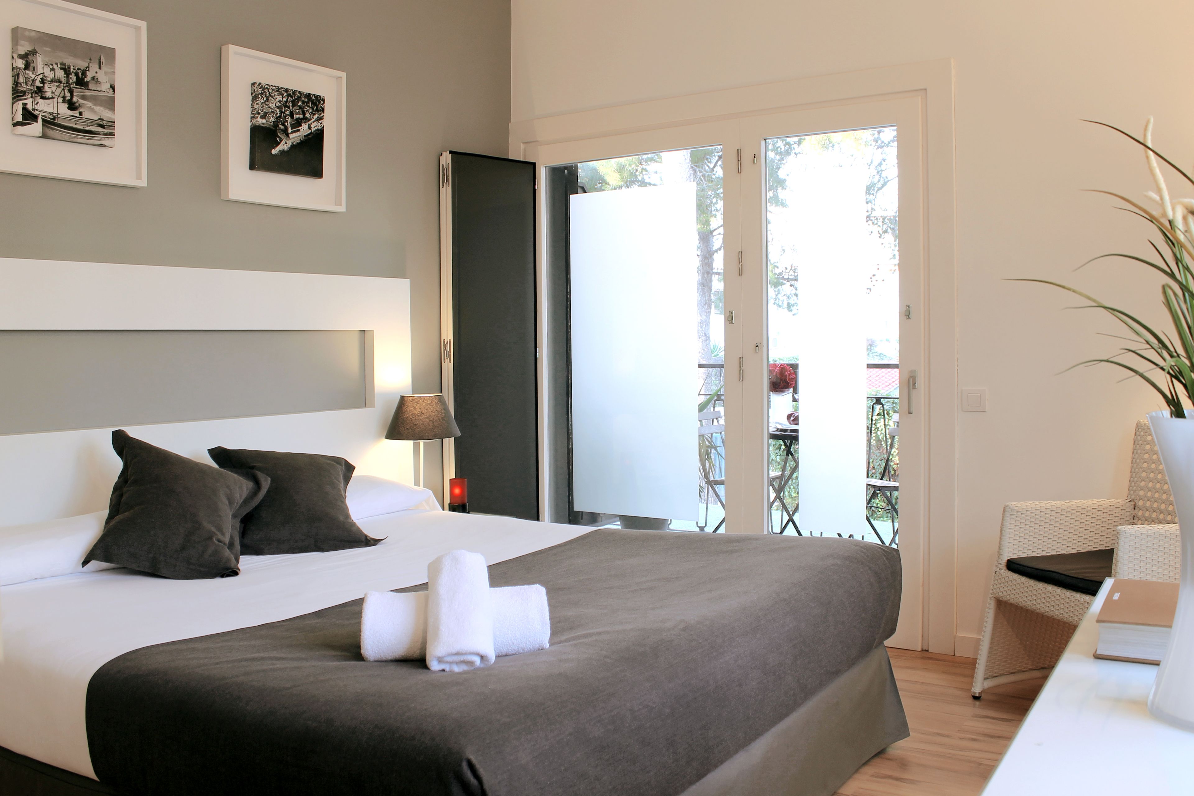 Ein modernes Hotelzimmer mit einem großen Bett, einem Schreibtisch und einem Balkon mit Blick.
