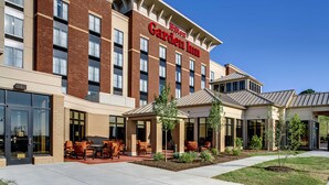 A Hilton Garden Inn with a brick facade, large windows, and outdoor seating area. - Hilton Garden Inn Pittsburgh/Cranberry (Cranberry Township)